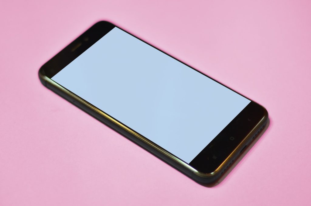 black Android smartphone on pink background