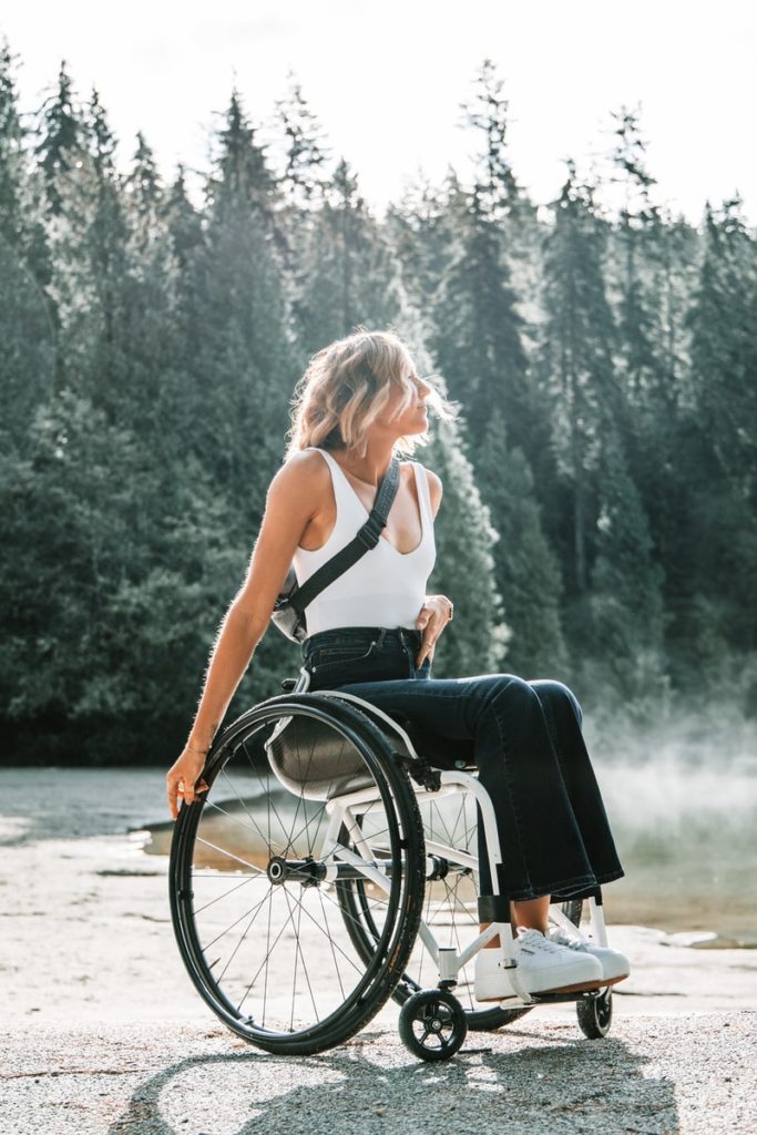 woman riding wheelchair near trees