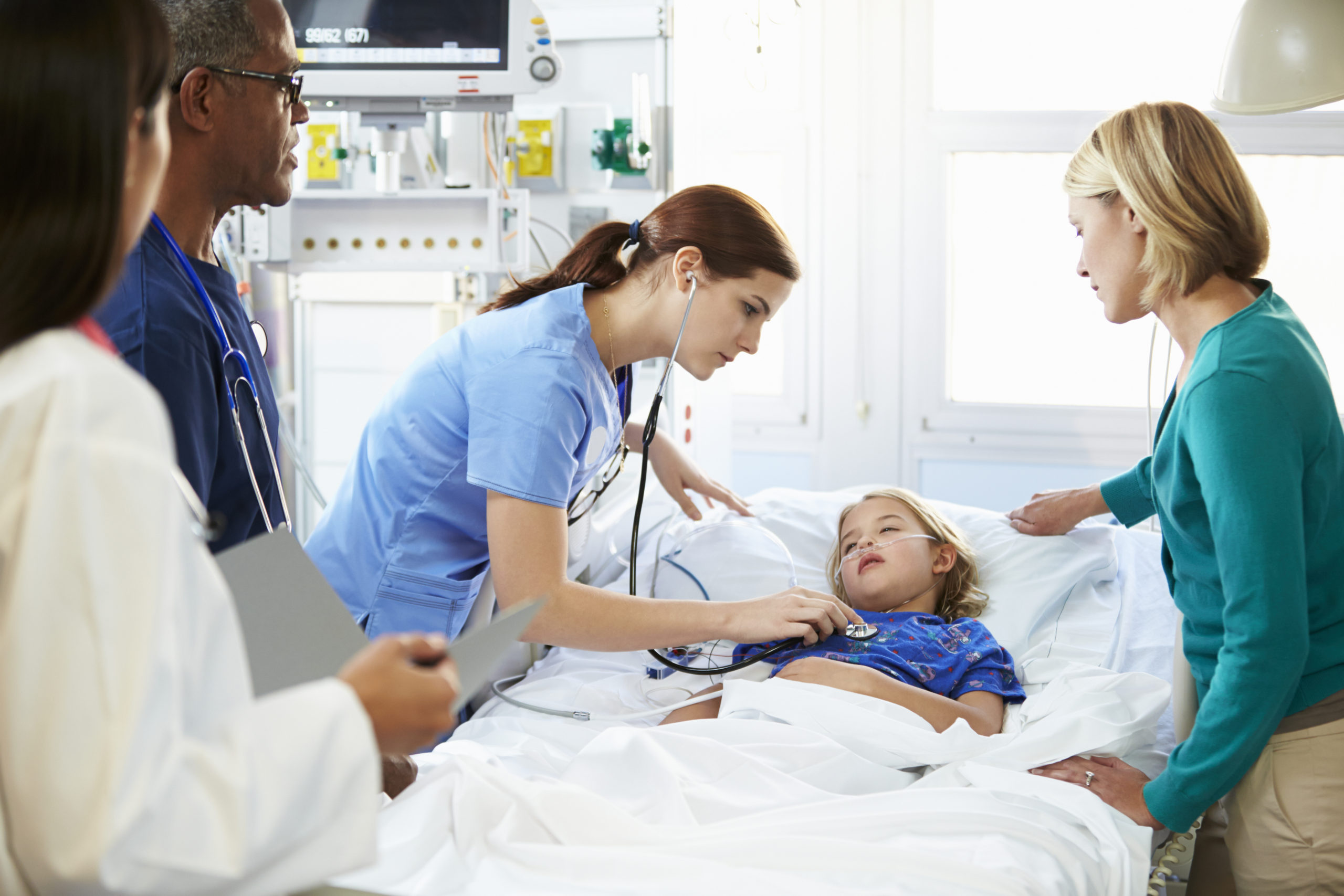 Sick child in ICU with parent and doctors standing nearby