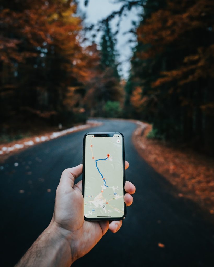 person holding white iphone looking at a map